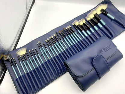 32-piece blue makeup brush set with synthetic fibers in a navy blue leather roll case