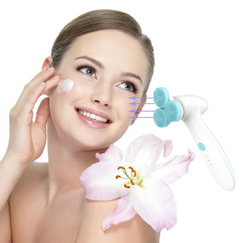 Smiling woman applying facial cream with 3D blue silicone facial cleansing brush and pink lily