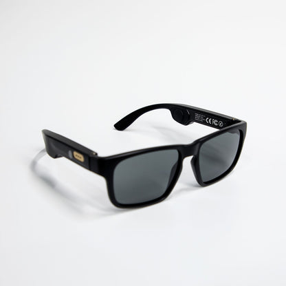Black smart Bluetooth sunglasses with rectangular dark lenses on white background