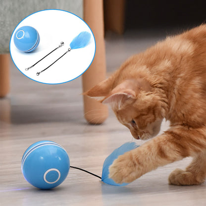 Orange tabby cat playing with a blue USB rechargeable smart cat ball toy with feather attachment on wooden floor