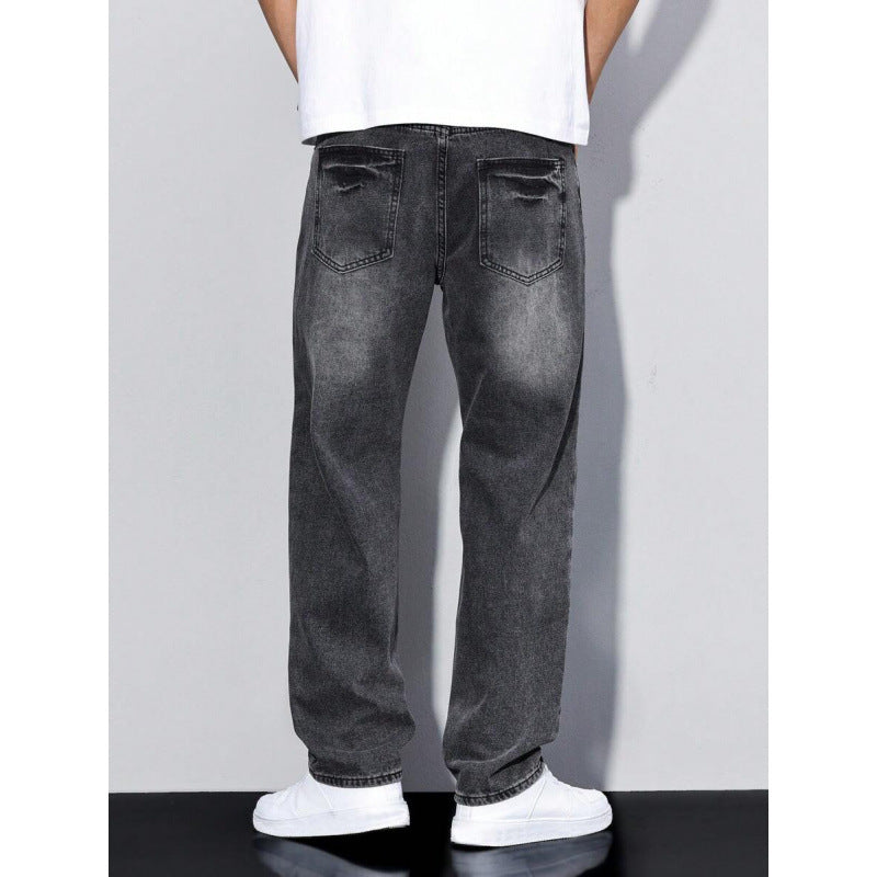 Back view of men's black faded relaxed fit jeans with distressed back pockets, paired with white sneakers