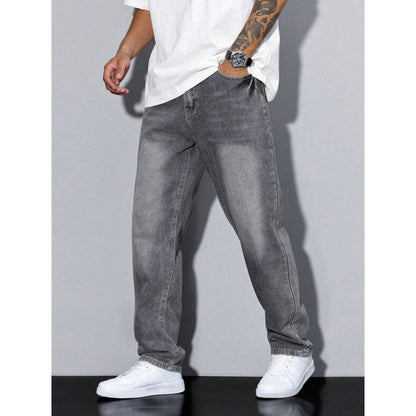 man wearing loose fit faded black straight leg jeans with white sneakers and white t-shirt