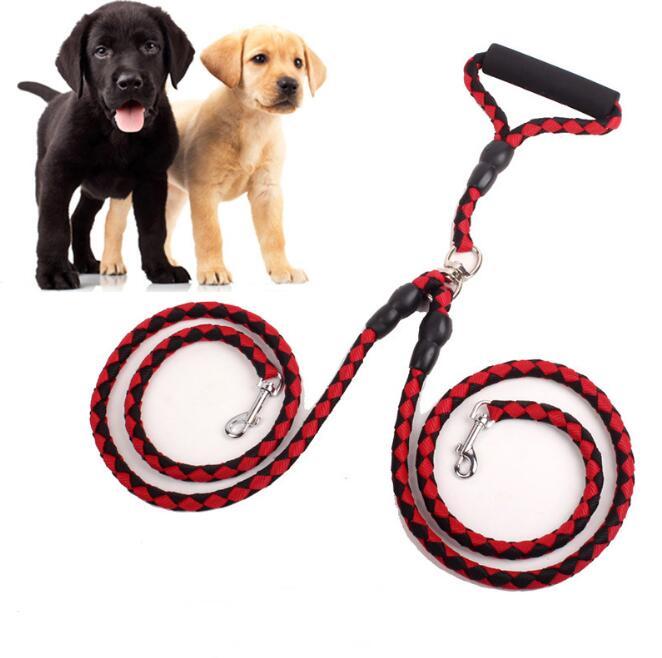 Double dog leash in red and black braided rope with padded handle, shown with black and yellow Labrador puppies
