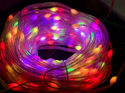 Colorful coiled string of LED Christmas lights glowing in red, purple, yellow, green, and blue