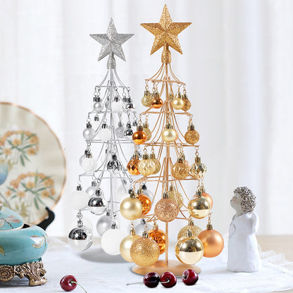 Modern bronze and silver metal Christmas tree ornaments with star toppers and gold, silver, and bronze baubles on table
