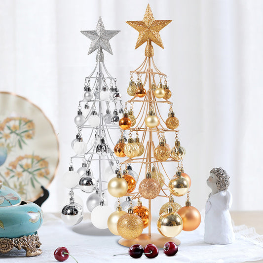Modern bronze and silver metal Christmas tree ornaments with star toppers and gold, silver, and bronze baubles on table