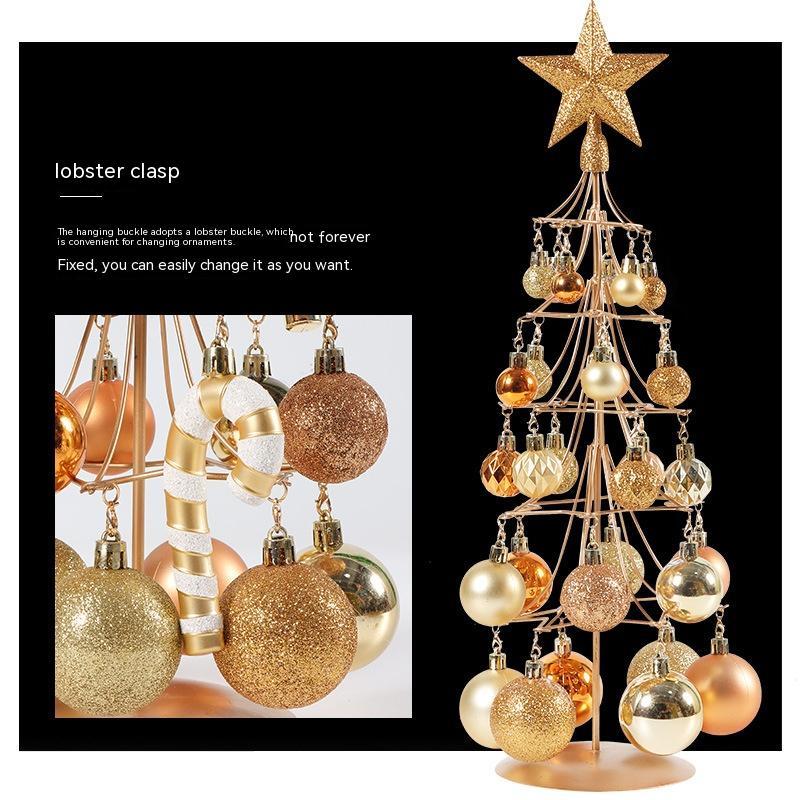 modern metal Christmas tree with bronze, gold, and iron ornaments and star topper on black background