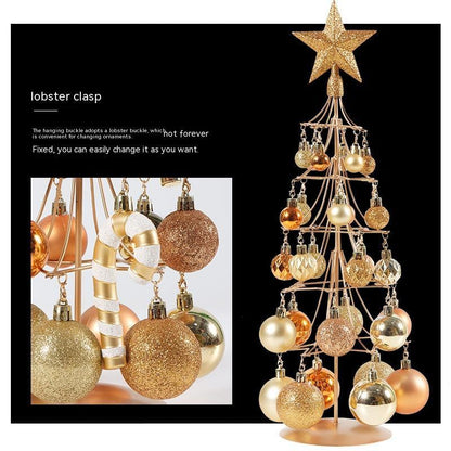 modern metal Christmas tree with bronze, gold, and iron ornaments and star topper on black background