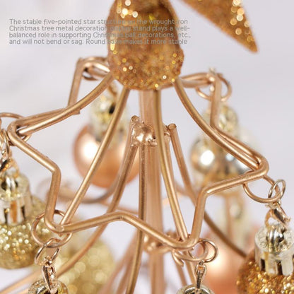 Close-up of bronze-gold metal star Christmas ornament stand with hanging metallic baubles