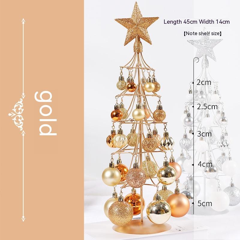 Gold metal tabletop Christmas tree adorned with various gold and bronze baubles and a glittery star topper