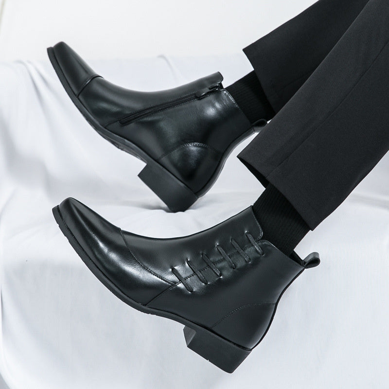 Black leather Chelsea boots with pointed toes and side zipper on feet with black pants