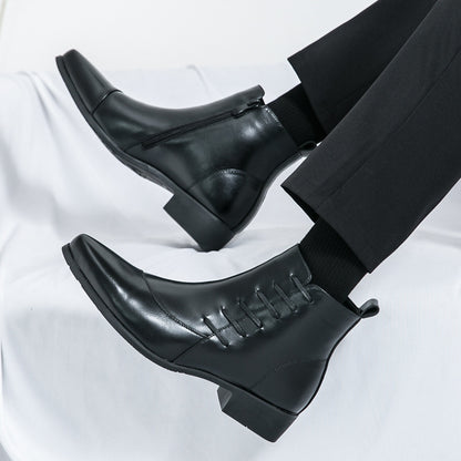 Black leather Chelsea boots with pointed toes and side zipper on feet with black pants