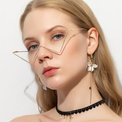 Close-up of woman wearing unique half-frame metal glasses with rhinestones, floral earrings, and black lace choker