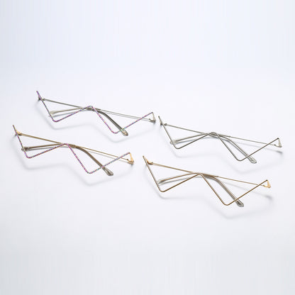 Set of four half-frame metal glasses in gold and silver with zigzag decorative design on white background