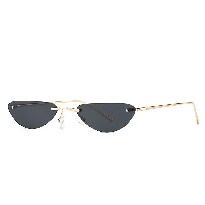 Narrow cat eye sunglasses with black lenses and thin gold metal frame on white background