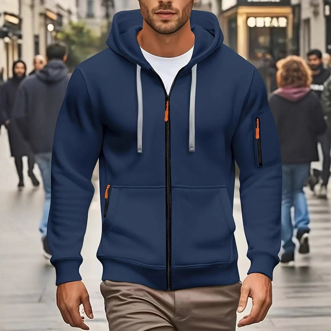 Man wearing navy blue zip-up hoodie with hood and gray drawstrings walking on busy city street
