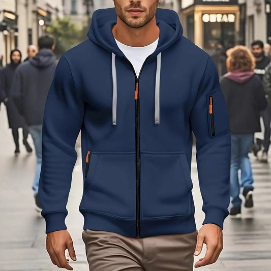 Man wearing navy blue zip-up hoodie with hood and gray drawstrings walking on busy city street