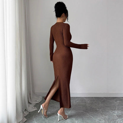 Woman wearing coffee brown ribbed knit midi dress with long sleeves and back slit, white heels on marble floor