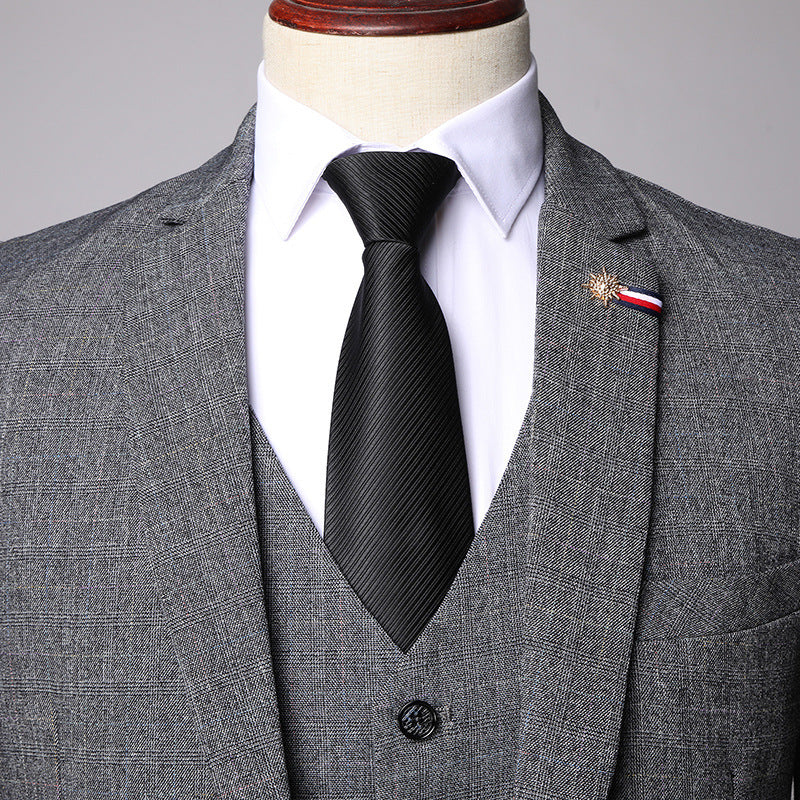 Gray checkered men's three-piece suit with white shirt and black tie on mannequin