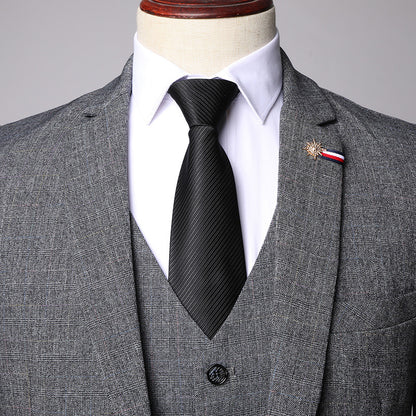 Gray checkered men's three-piece suit with white shirt and black tie on mannequin