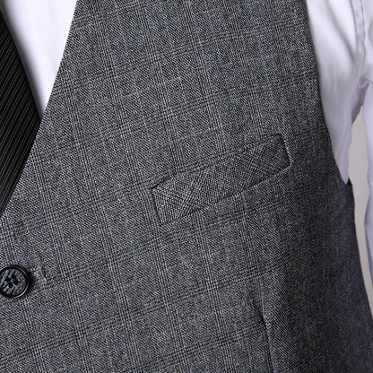 Close-up of men's grey textured three-piece suit vest over white shirt with black striped tie