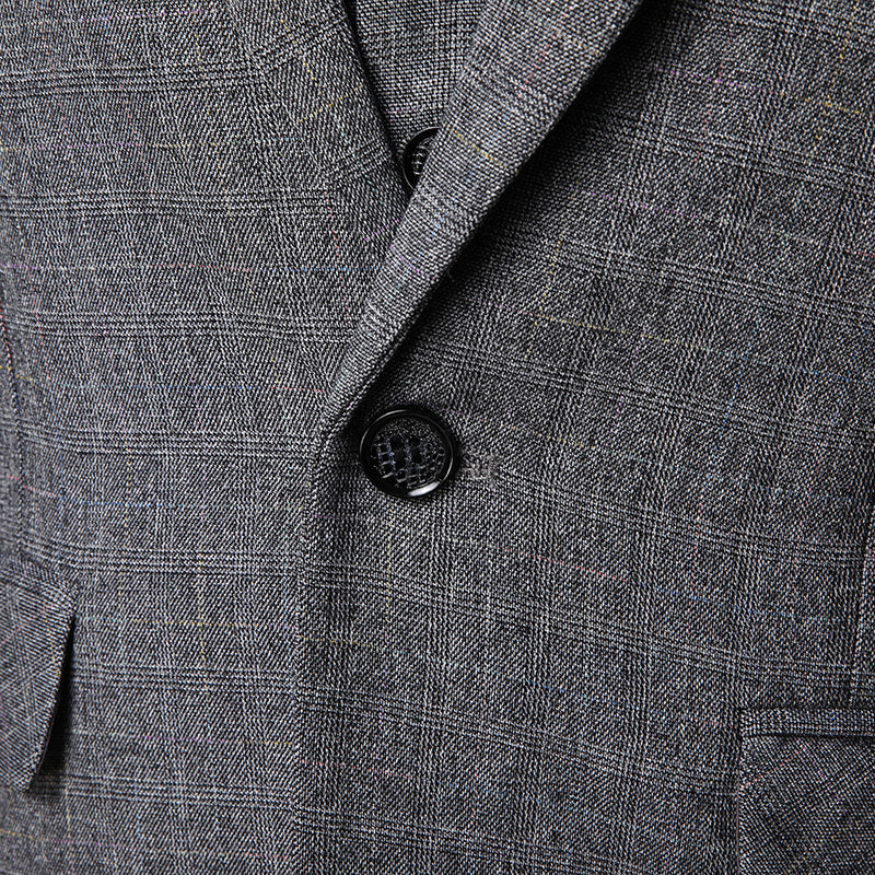 Close-up of men's gray plaid suit jacket with black button and notch lapel detail