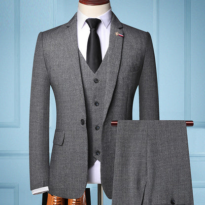 Men's grey three-piece suit with blazer, vest, trousers, white shirt, black tie on mannequin