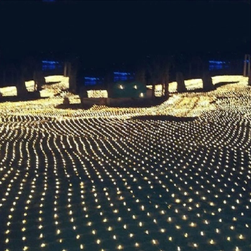 Outdoor ground covered with warm white LED net lights creating a glowing grid pattern at night