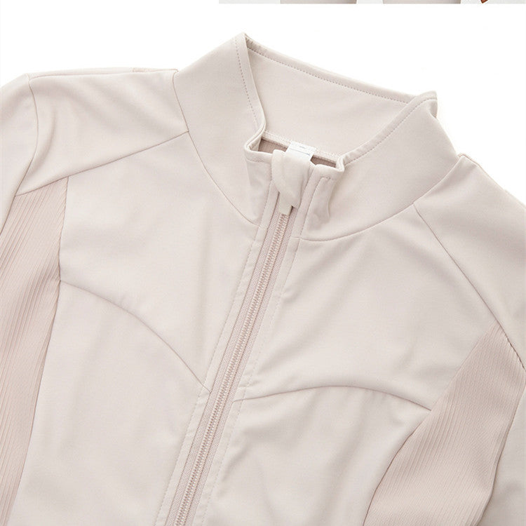 Close-up of beige nylon blend activewear jacket with front zipper and stand collar