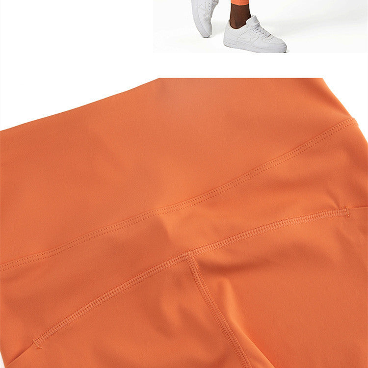 Close-up of orange nylon blend activewear leggings with visible flatlock stitching detail