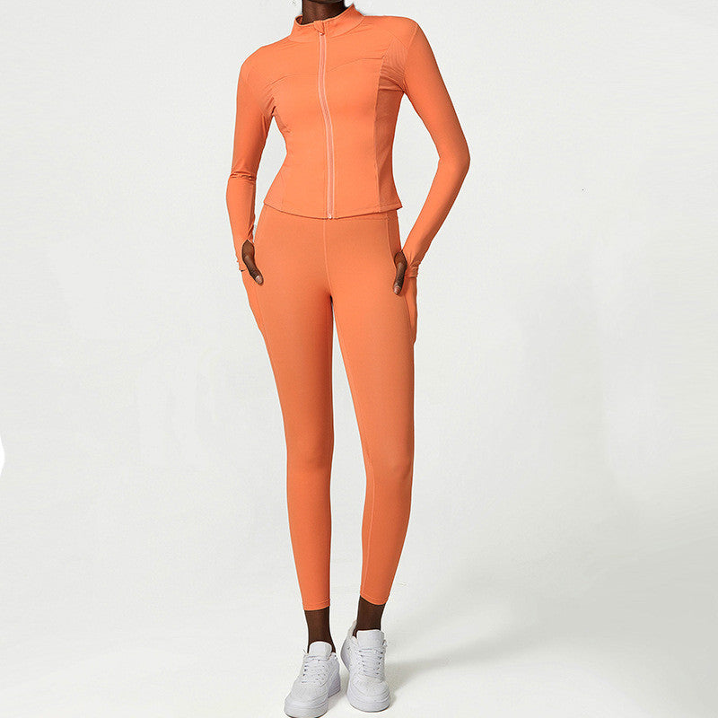 Woman wearing orange two-piece activewear set with long-sleeve zip-up jacket and leggings