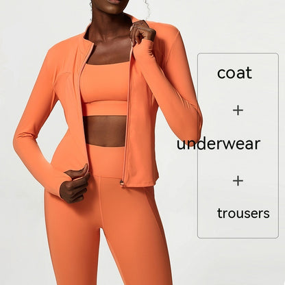 Woman wearing a bright orange three-piece activewear set including coat, sports bra, and high-waist tights