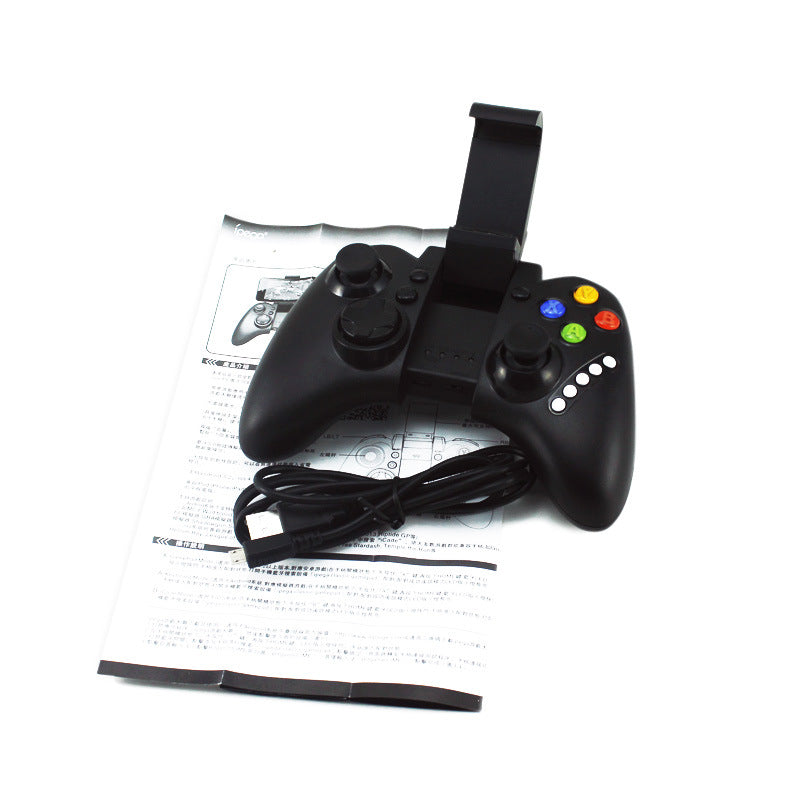 Black Bluetooth game controller with joystick, colored buttons, phone holder, USB cable, and manual on white background