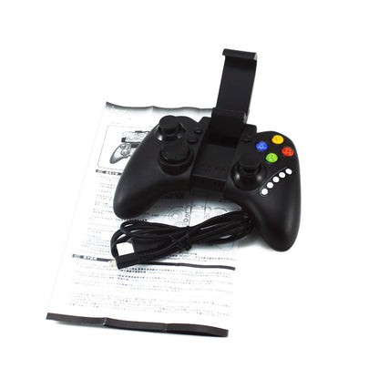 Black Bluetooth game controller with joystick, colored buttons, phone holder, USB cable, and manual on white background