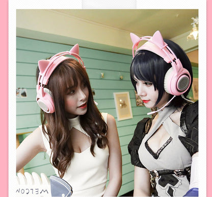 Two women wearing pink cat ear gaming headsets with USB 7.1 surround sound in a cozy room