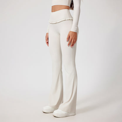 Woman wearing white high-waist yoga pants with ruffle detail and white sneakers
