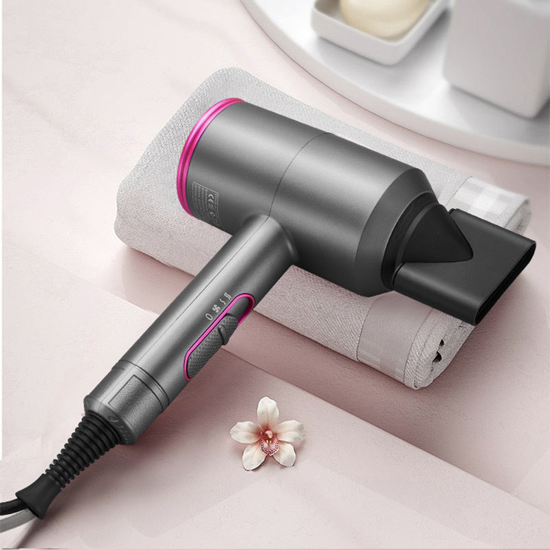 Gray and pink ionic hair dryer with concentrator nozzle on white towel with flower on pink surface
