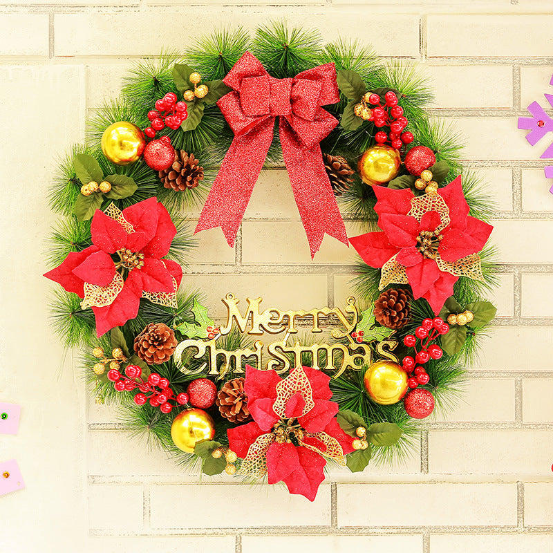 Christmas wreath with red poinsettias, pine cones, gold ornaments, berries, and red glitter bow on wall