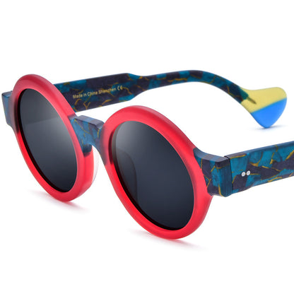 Round sunglasses with frosted red front frame and blue marble-patterned temples, black polarized lenses