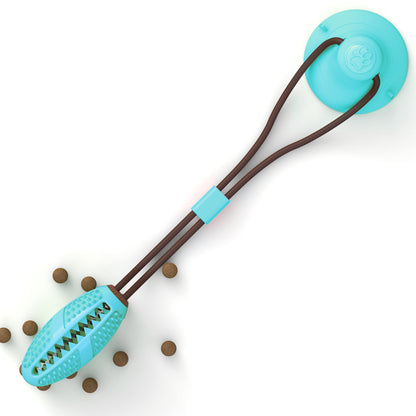 Blue interactive dog chew ball toy with suction cup and brown rope, surrounded by small brown kibble