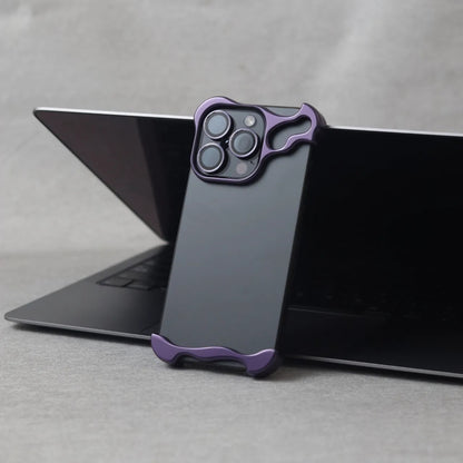 Black iPhone 15 Pro Max with purple zinc alloy protective case standing against a laptop