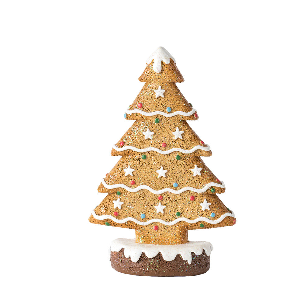 Ginger cake Christmas tree decoration with white icing stars and colorful candy dots on a snowy base