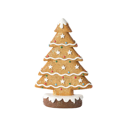 Ginger cake Christmas tree decoration with white icing stars and colorful candy dots on a snowy base