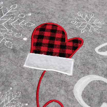 Gray fabric Christmas tree skirt with red and black plaid mitten and white embroidered snowflakes