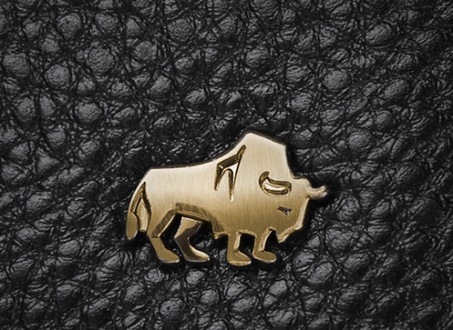 Gold American bison emblem on textured black leather surface