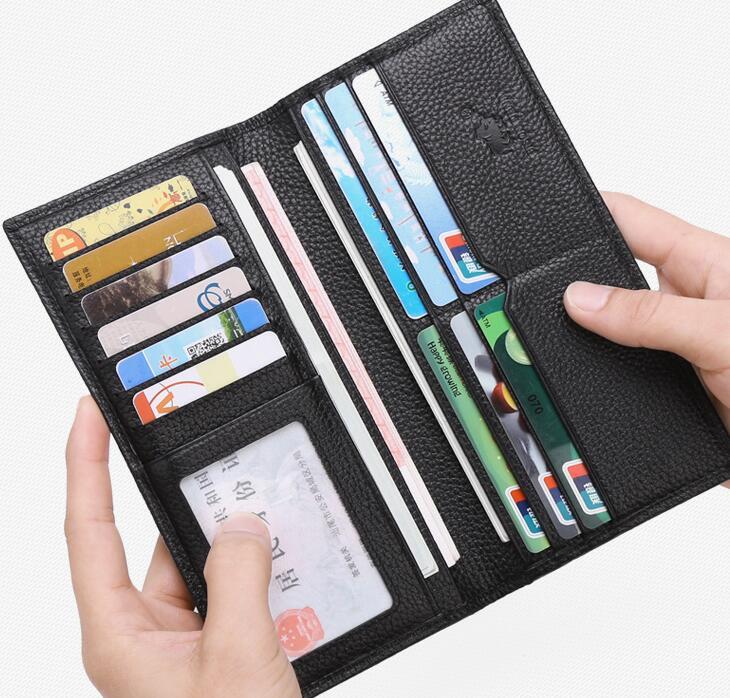 Black leather wallet open showing multiple card slots filled with cards and a transparent ID window held by hands