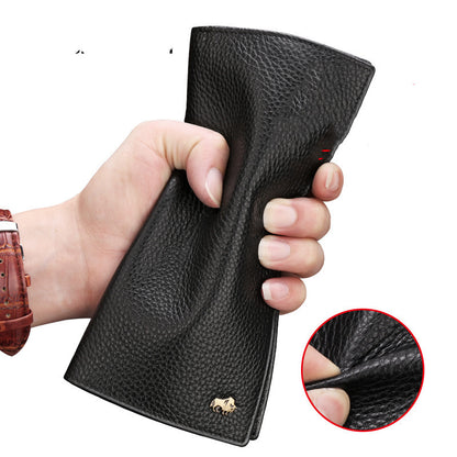 Black pebbled leather wallet held in hand with small gold bison logo, showing durable texture