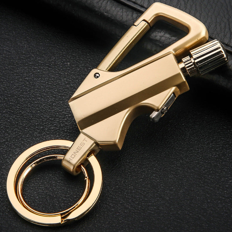 Gold metal keychain lighter with flint wheel and bottle opener on black background