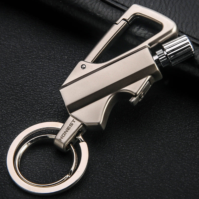 Metallic gold keychain lighter with carabiner clip and ignition wheel on black surface