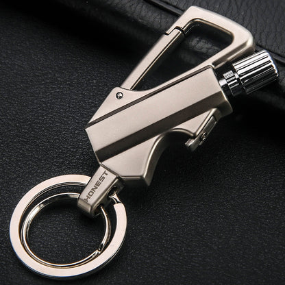 Metallic gold keychain lighter with carabiner clip and ignition wheel on black surface
